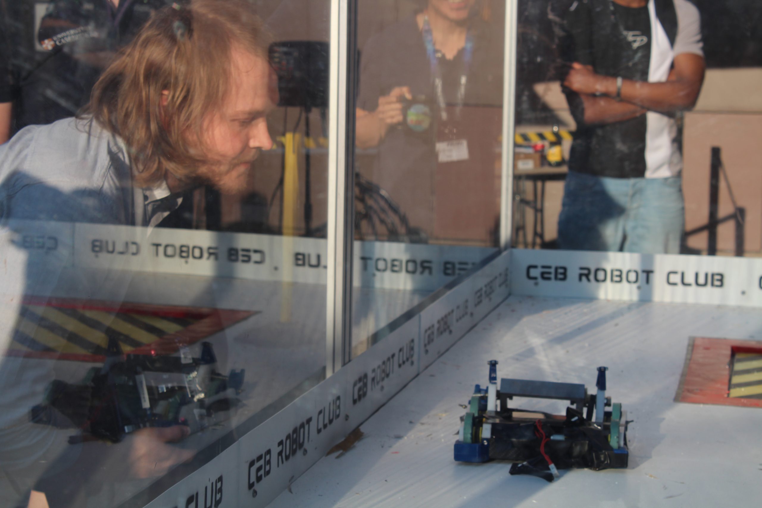 Senior research associate Edward Ward looking at his robot through a perspex shield.