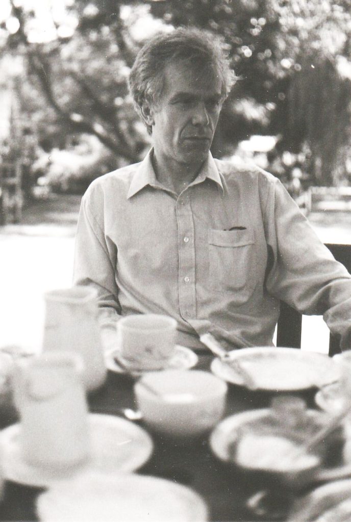 Black and white portrait of a man sitting in a garden