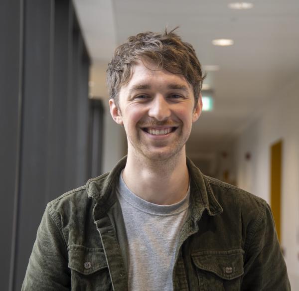 Portrait of a man standing in a laboratory corridor.