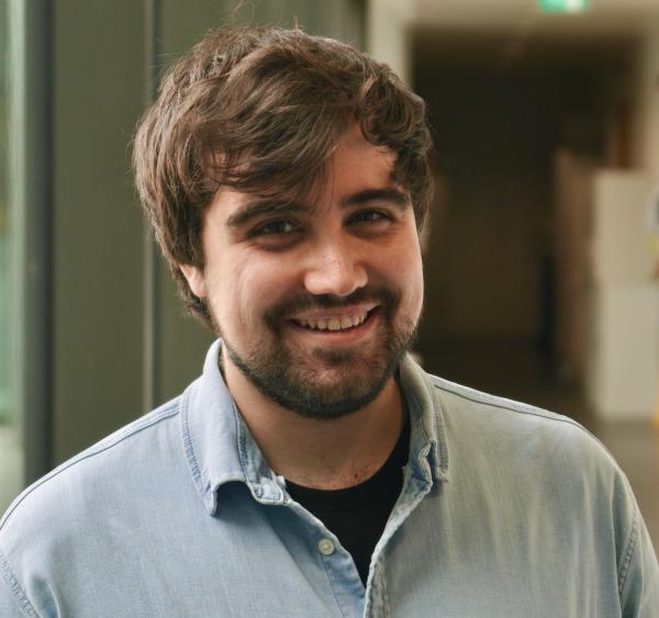 Portrait of a man standing in a laboratory corridor.