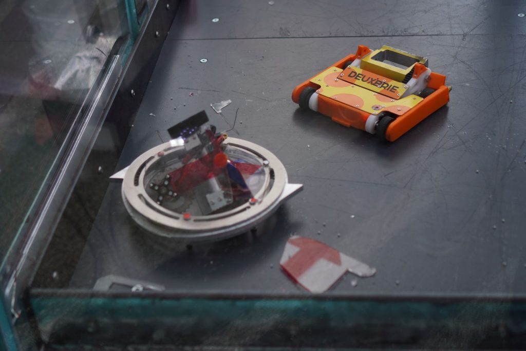 The aftermath of a big hit between Deuxbrie robot and Jon Cowper's robot in the arena.