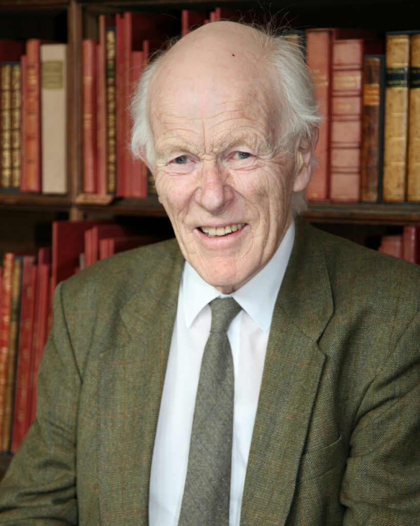 Prof John Davidson professional academic headshot with books in background.