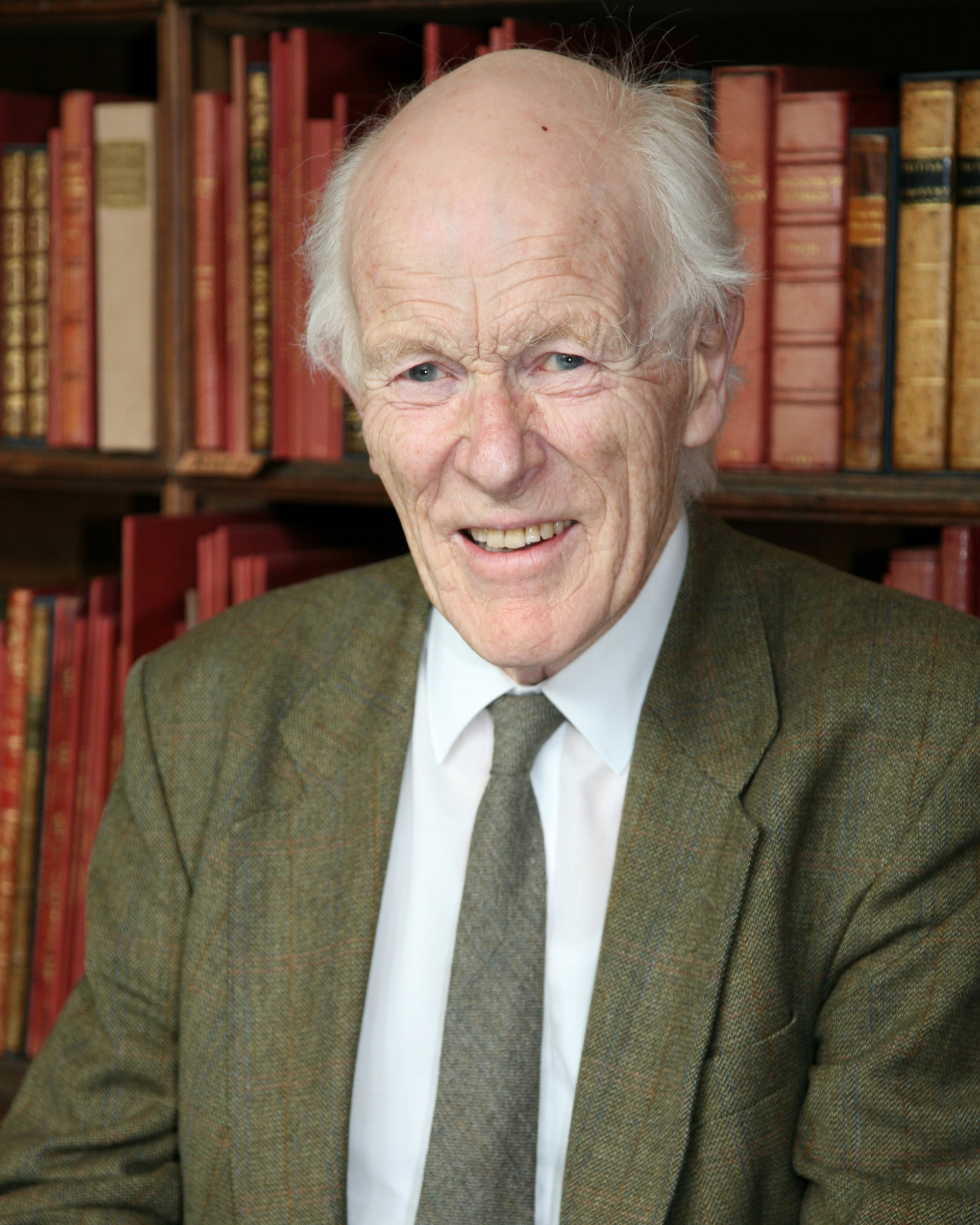 Prof John Davidson professional academic headshot with books in background.